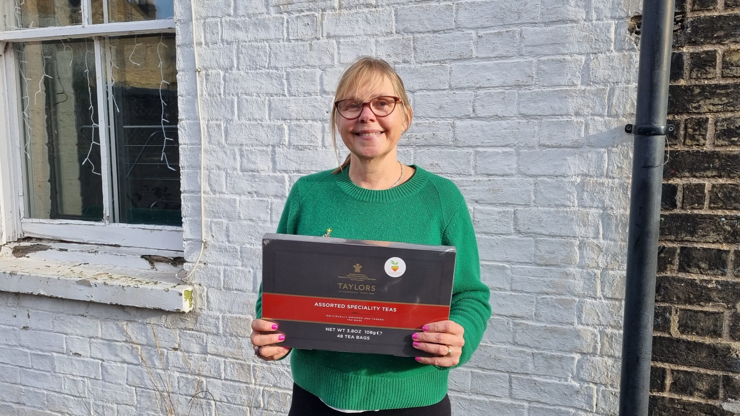 Sophie Evans is the winner of the Karim Foundation's latest Free Prize Draw, which was held at the Mill Road Winter Fair 2023. She is happily holding an assorted speciality tea selection box.